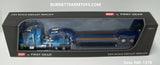 Item #60-1376 Baby Blue Peterbilt 389 Pride-N-Class 36-inch Flattop Sleeper with Blue Metallic Tri-Axle Fontaine Magnitude Lowboy Trailer with Detachable Neck - 1/64 Scale - DCP by First Gear