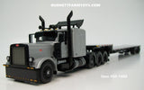 Item #60-1488 Silver Black Tri-Axle Peterbilt 389 63-inch Flattop Sleeper with Turbo Wing and Silver Deck Black Frame Spread Axle Transcraft Stepdeck Trailer - 1/64 Scale - DCP by First Gear
