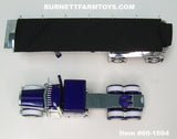 Item #60-1694 Purple Metallic White Peterbilt 389 63-inch Flattop Sleeper with Chrome Sided Black Tarp Purple Metallic Frame Spread Axle MAC Round Dump Trailer - 1/64 Scale - DCP by First Gear