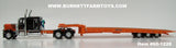 Item #60-1228 Black Orange Peterbilt 389 63-inch Flattop Sleeper with Orange Tri-Axle Talbert 5553TA Slide Axle Flatbed Trailer - 1/64 Scale - DCP